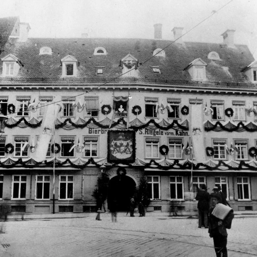 Ein schwarz-weiß Foto der Fassade der ehemaligen Riegele Brauerei am Königsplatz Augsburg