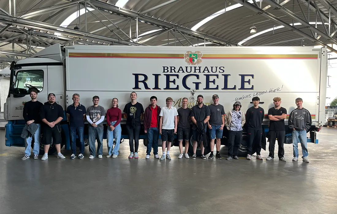 Alle Riegele Auszubildenden stehen vor einem weißen LKW mit Riegele Logo